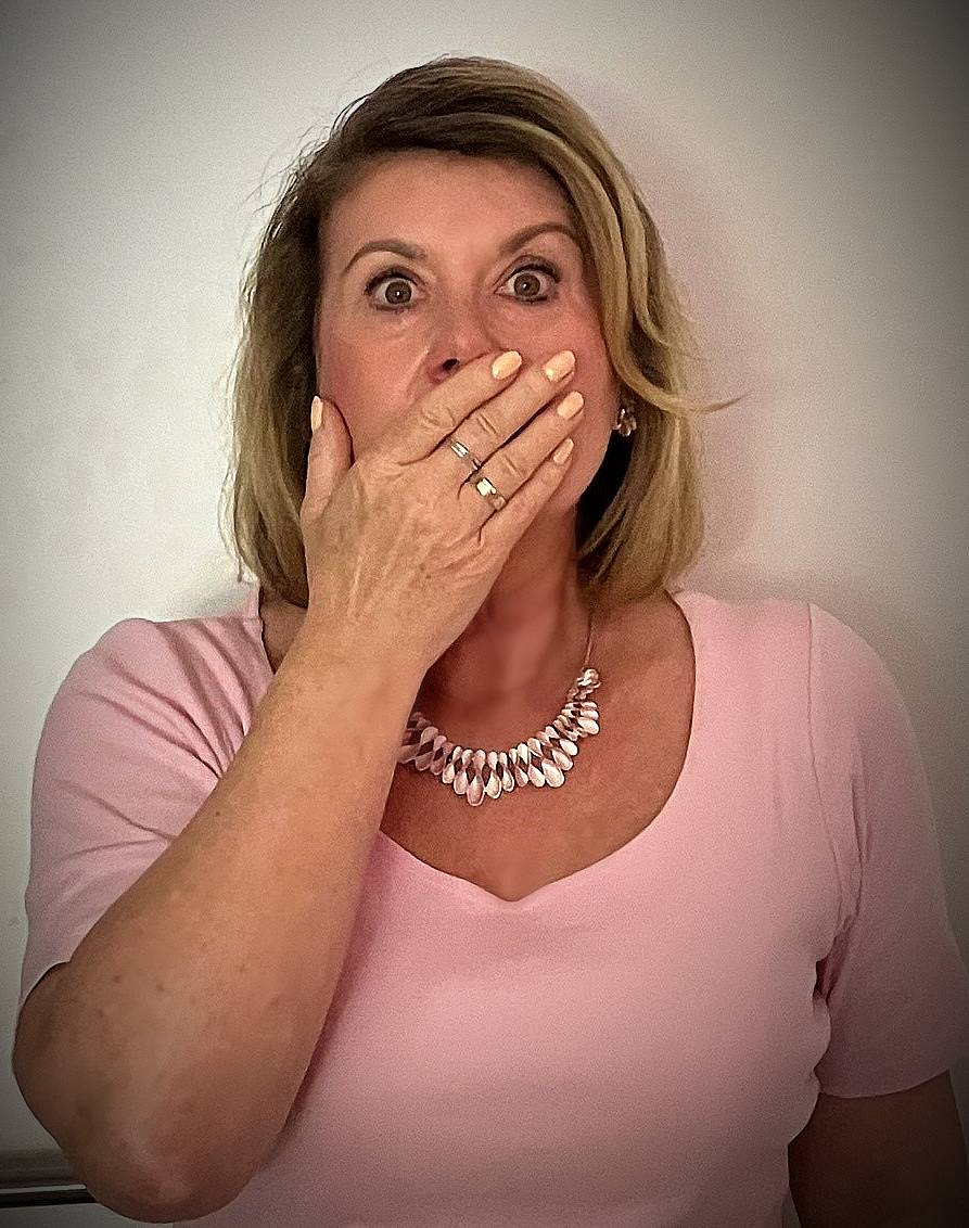 Bild zeigt Frau mit weit aufgerissenen Augen und der Hand vor dem Mund. Ausdruck Sprachlosigkeit